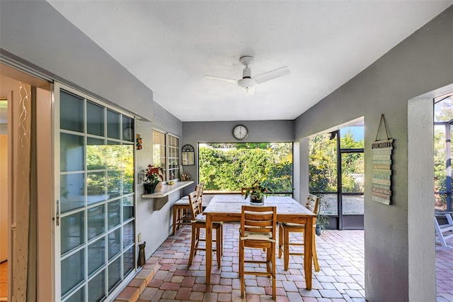 dining space featuring brick floor and ceiling fan