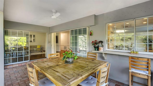 dining space featuring brick floor and a ceiling fan