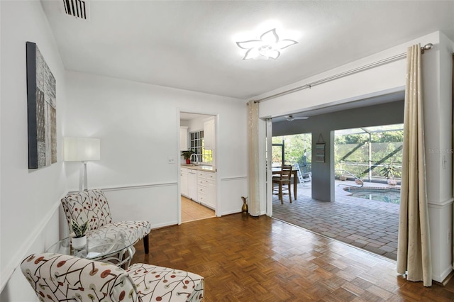 living area with baseboards and visible vents