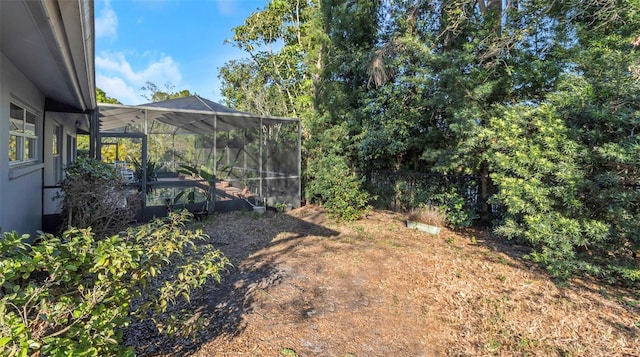 view of yard featuring a lanai and fence