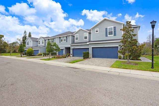 view of front of property featuring a residential view, stucco siding, an attached garage, and driveway