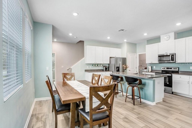 dining room with light wood finished floors, visible vents, recessed lighting, and baseboards