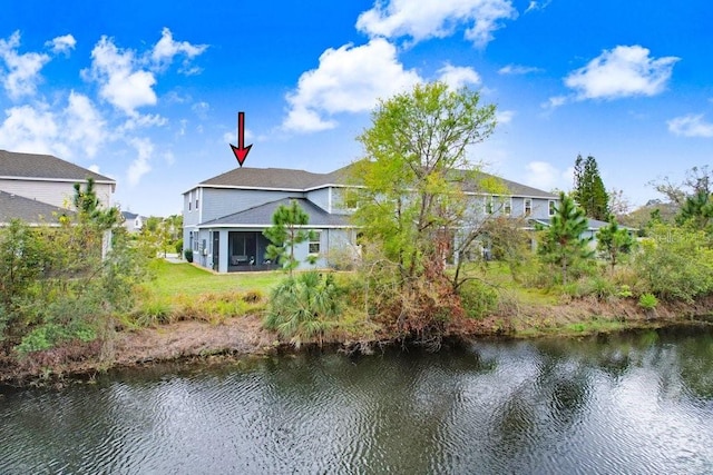 rear view of property with a water view and a sunroom