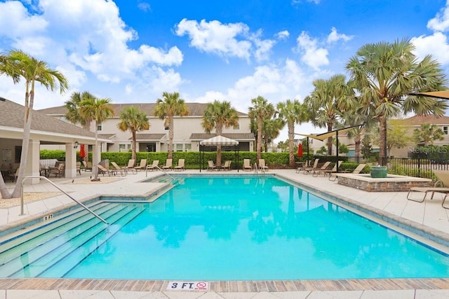 community pool featuring a patio area, a residential view, and fence