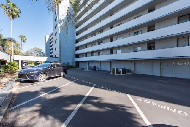 view of building exterior featuring central AC unit and uncovered parking