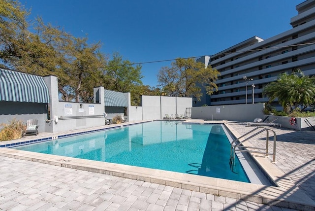 pool with a patio area and fence