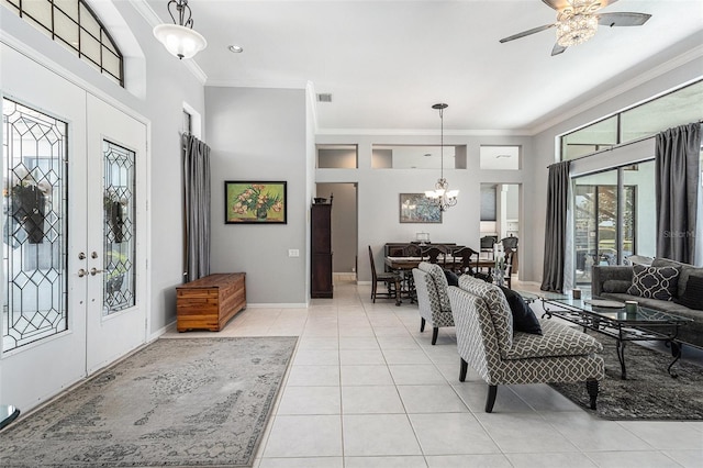 foyer entrance with visible vents, ornamental molding, ceiling fan with notable chandelier, french doors, and light tile patterned flooring