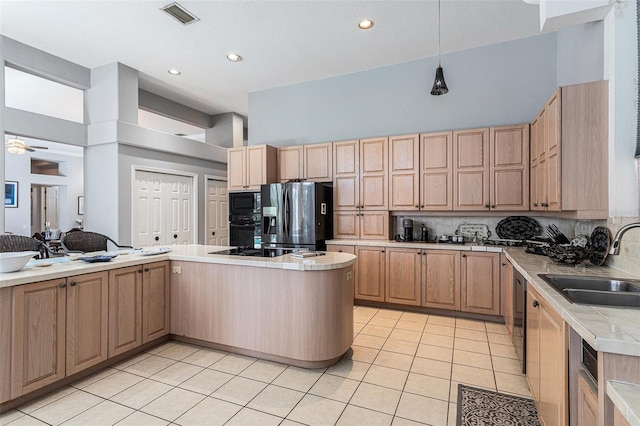 kitchen featuring visible vents, light brown cabinets, light tile patterned flooring, black appliances, and a sink