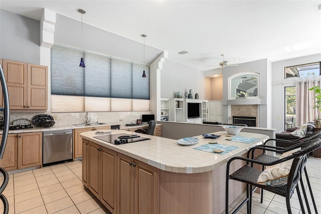 kitchen with a center island, ceiling fan, tile counters, black electric cooktop, and stainless steel dishwasher