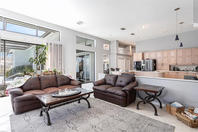 living room with light tile patterned flooring, recessed lighting, visible vents, and a towering ceiling