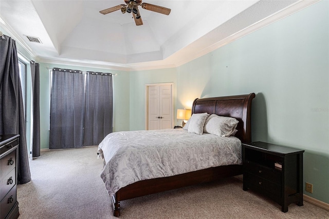 bedroom with a raised ceiling, visible vents, carpet floors, and ceiling fan