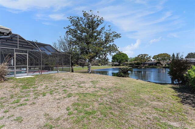 view of yard featuring a water view, a pool, and a lanai