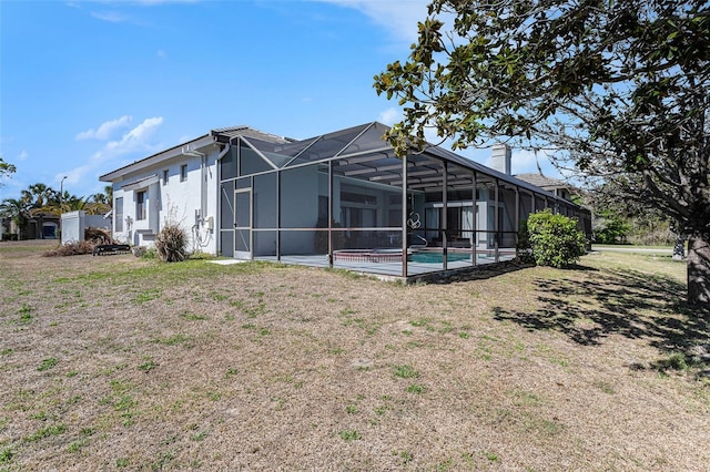 back of property featuring stucco siding, a lawn, an outdoor pool, a lanai, and a chimney