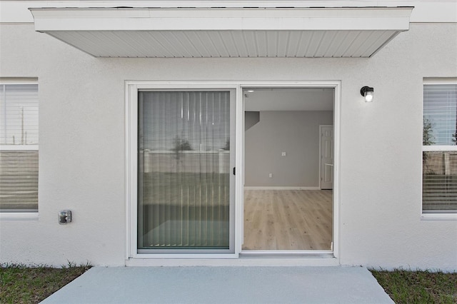 property entrance with stucco siding