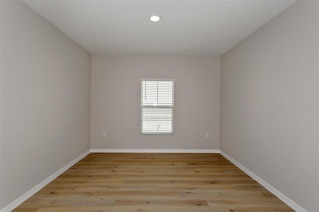 unfurnished room with recessed lighting, baseboards, and light wood-style flooring