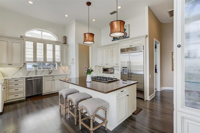 kitchen with tasteful backsplash, visible vents, a center island, a kitchen breakfast bar, and stainless steel appliances