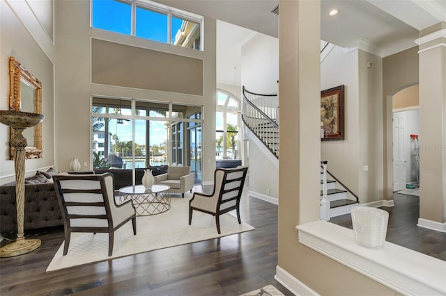 foyer featuring stairs, a high ceiling, wood finished floors, and baseboards