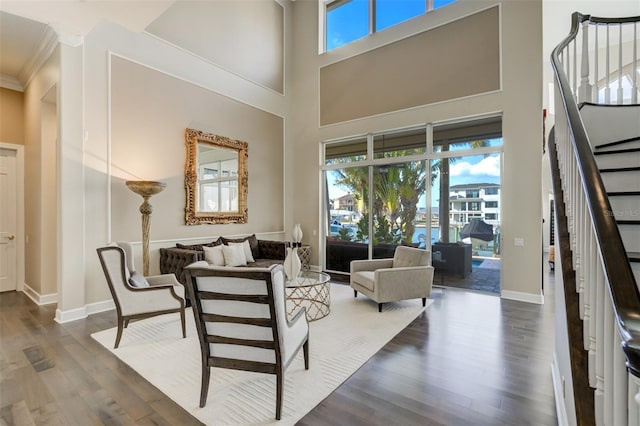 sitting room featuring dark wood-style floors, stairway, a high ceiling, and baseboards