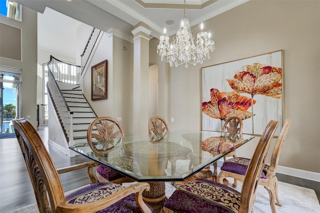 dining room featuring wood finished floors, crown molding, baseboards, a chandelier, and stairs