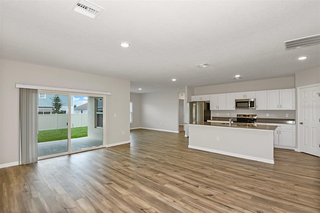 kitchen with white cabinetry, open floor plan, visible vents, and appliances with stainless steel finishes