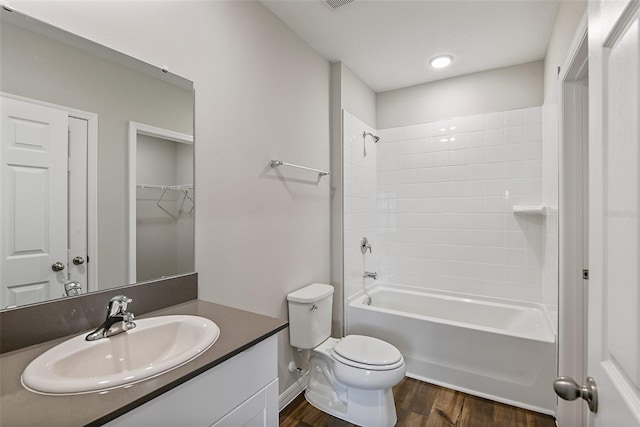 full bathroom with visible vents, toilet, wood finished floors, washtub / shower combination, and vanity