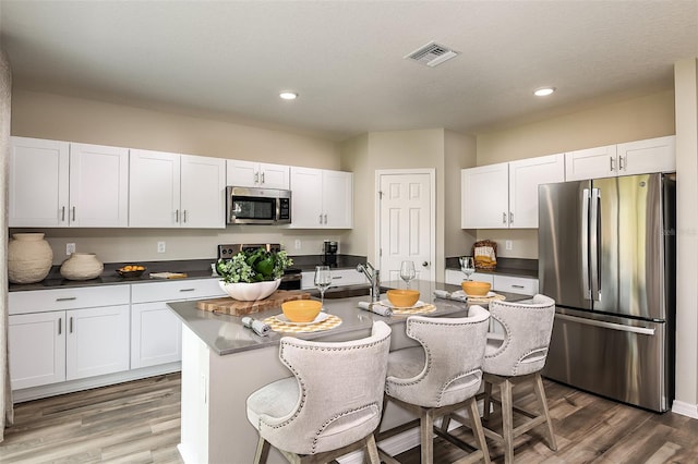 kitchen with white cabinetry, visible vents, appliances with stainless steel finishes, and a sink