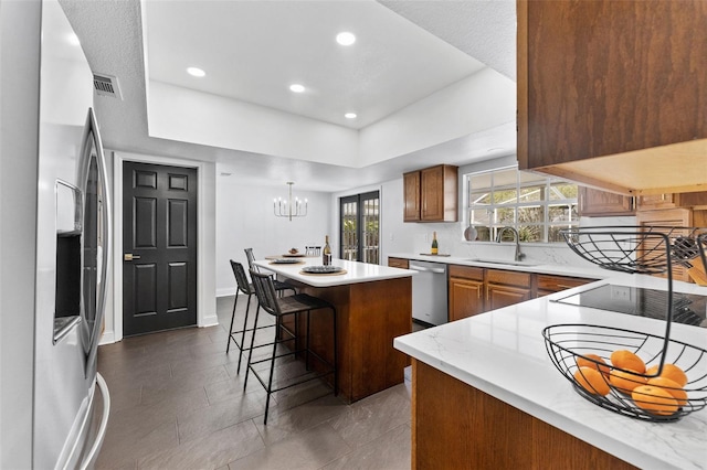 15703 Jericho Dr, Odessa, FL 33556 - kitchen featuring stainless steel appliances, a sink, a center island, a kitchen bar, and a raised ceiling