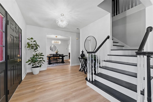 15703 Jericho Dr, Odessa, FL 33556 - foyer entrance with a chandelier, stairs, light wood finished floors, and baseboards