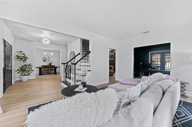 15703 Jericho Dr, Odessa, FL 33556 - living area featuring stairs, a fireplace, a chandelier, wood finished floors, and baseboards