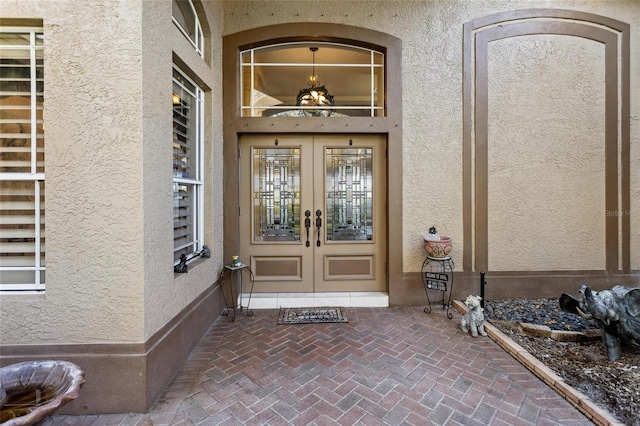 view of exterior entry with french doors and stucco siding