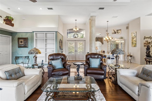 living room with a chandelier, visible vents, french doors, and wood finished floors