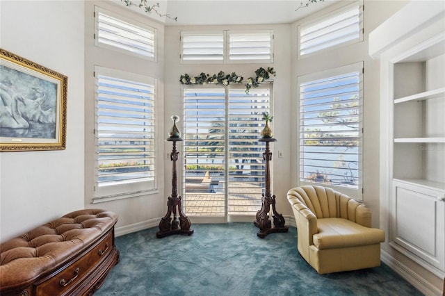 living area with baseboards and carpet