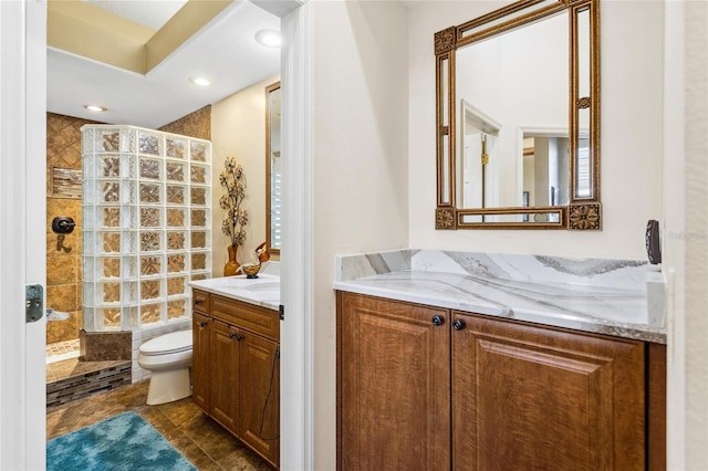 bathroom featuring vanity, toilet, recessed lighting, and walk in shower