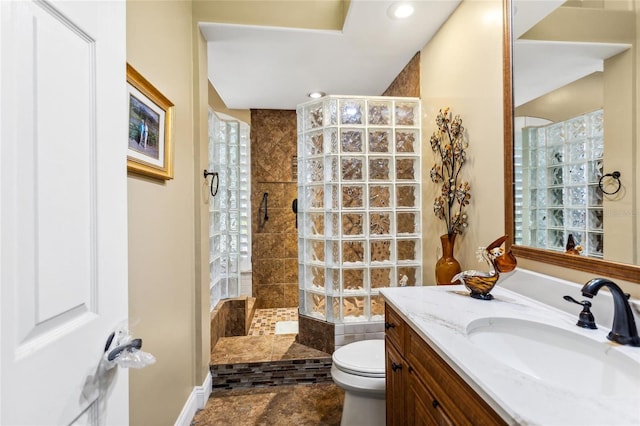 bathroom featuring recessed lighting, toilet, vanity, and a walk in shower