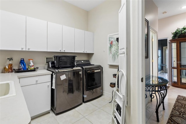 washroom with washer and dryer, light tile patterned floors, cabinet space, and a sink