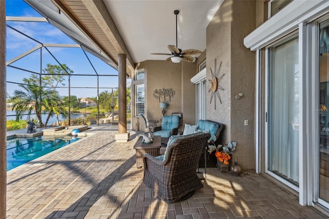 view of patio featuring ceiling fan, a water view, glass enclosure, outdoor lounge area, and an outdoor pool