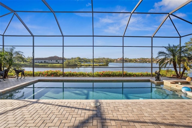 view of swimming pool with glass enclosure, a patio, and a water view