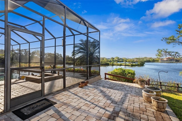 view of patio / terrace with glass enclosure and a water view