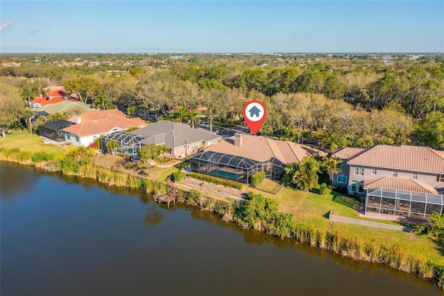 birds eye view of property with a wooded view, a water view, and a residential view