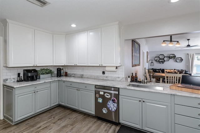 kitchen featuring backsplash, dishwasher, gray cabinetry, and a sink