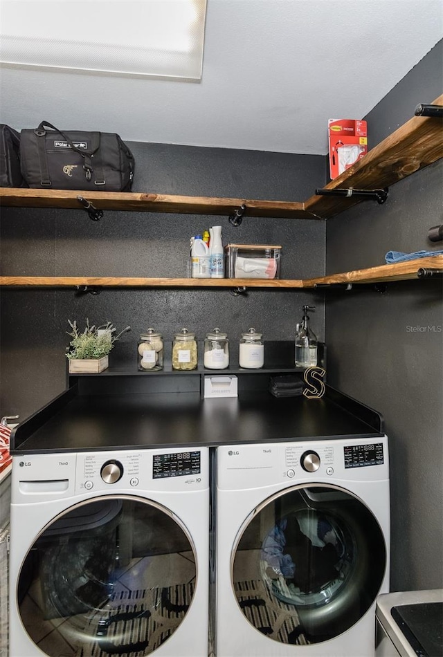 clothes washing area featuring separate washer and dryer and laundry area