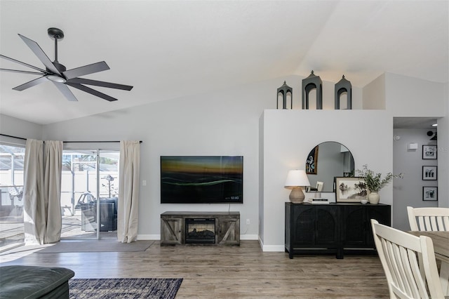 living room with baseboards, lofted ceiling, and wood finished floors