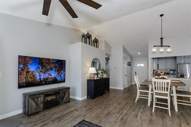 dining space featuring lofted ceiling, wood finished floors, baseboards, and ceiling fan