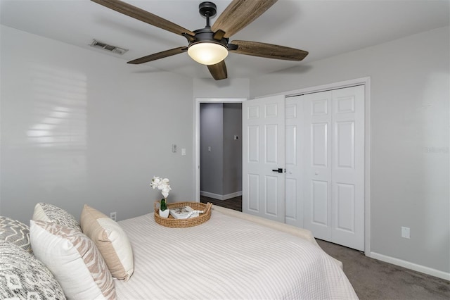 bedroom featuring a ceiling fan, visible vents, baseboards, a closet, and dark carpet