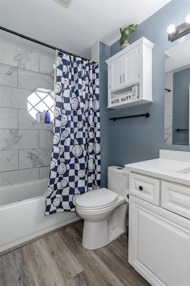 bathroom with shower / tub combo, toilet, wood finished floors, and vanity