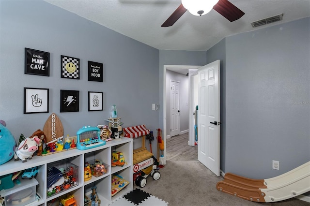 playroom featuring visible vents, carpet flooring, baseboards, and ceiling fan