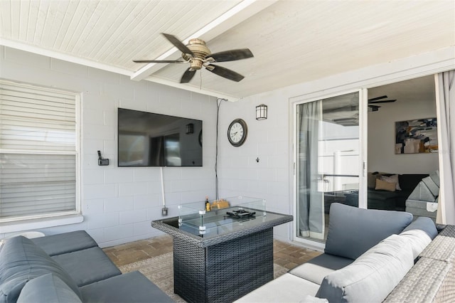 living area with wooden ceiling, concrete block wall, and ceiling fan