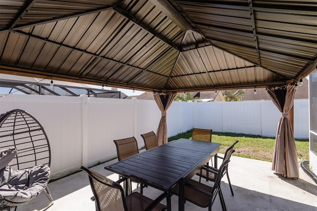 view of patio featuring a gazebo, outdoor dining area, and a fenced backyard