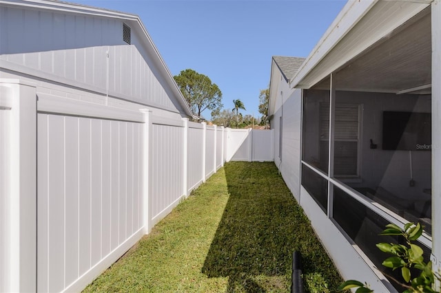 view of yard with a fenced backyard and a sunroom