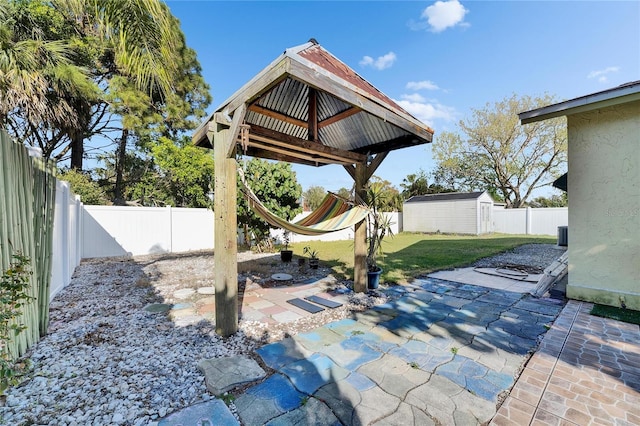 view of patio featuring a shed, an outdoor structure, and a fenced backyard